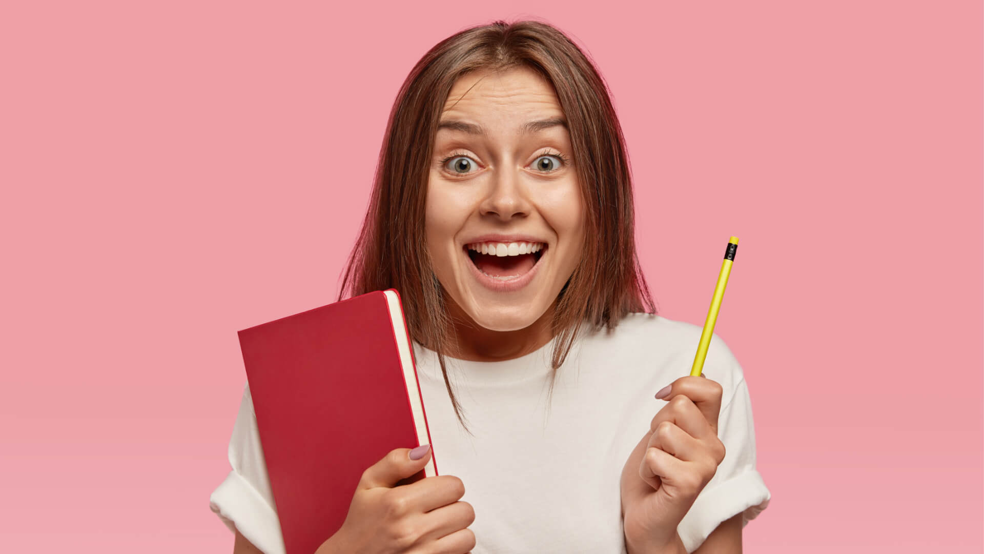uśmiechnięta dziewczyna trzyma ołówek i zeszyt